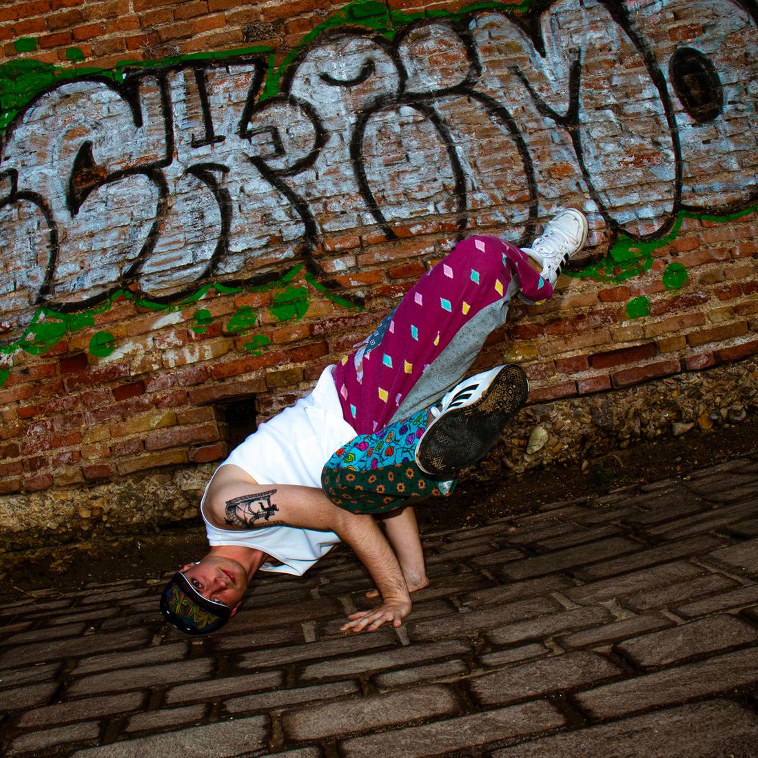 Ballerino in verticale davanti a un muro con graffiti